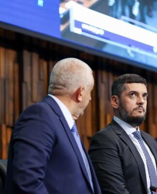 Presidente da Alerj, Rodrigo Bacellar olha para cima ao lado de outros deputados na mesa da assembleia