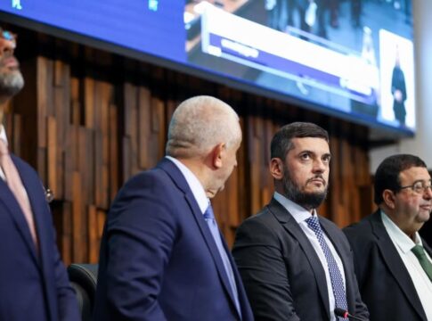 Presidente da Alerj, Rodrigo Bacellar olha para cima ao lado de outros deputados na mesa da assembleia