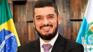 Foto institucional do deputado Rodrigo Bacellar, de terno e gravata, sorrindo para a câmera