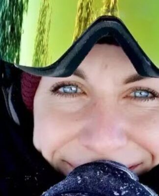 Foto aproximada do rosto da vítima, que veste trajes de proteção para caminhar na neve; se vê na imagem apenas seus olhos azuis e seu sorriso