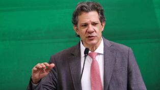 O ministro Fernando Haddad gesticula ao falar ao microfone
