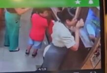 Foto da tela de um celular mostrando o instante em que a funcionária é golpeada no rosto