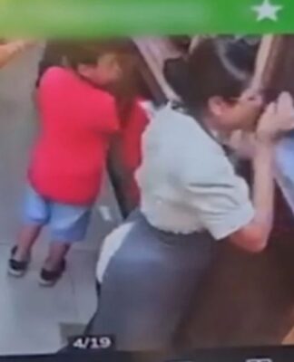 Foto da tela de um celular mostrando o instante em que a funcionária é golpeada no rosto