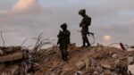 Dois soldados israelenses em cima de escombros na região de Gaza