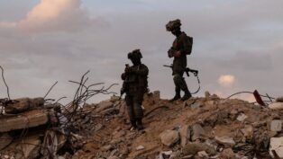 Dois soldados israelenses em cima de escombros na região de Gaza