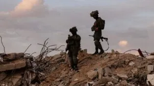 Dois soldados israelenses em cima de escombros na região de Gaza