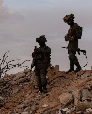 Dois soldados israelenses em cima de escombros na região de Gaza