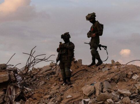 Dois soldados israelenses em cima de escombros na região de Gaza