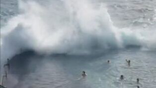 Momento em que uma onda gigante se choca contra a estrutura de uma piscina natural