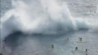 Momento em que uma onda gigante se choca contra a estrutura de uma piscina natural
