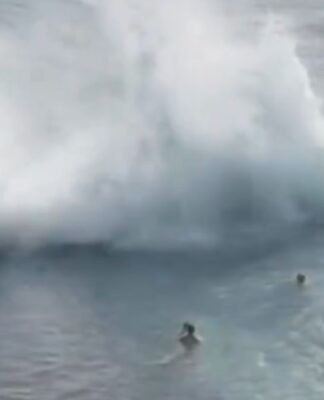 Momento em que uma onda gigante se choca contra a estrutura de uma piscina natural