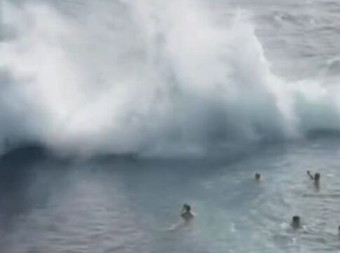Momento em que uma onda gigante se choca contra a estrutura de uma piscina natural