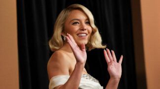 Sydney Sweeney (loira, olhos azuis, vestido branco) posando para foto no evento do Oscar