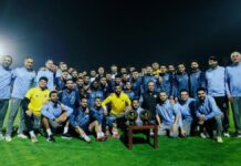 Elenco do Pyramids FC posando com troféu durante treino