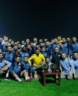 Elenco do Pyramids FC posando com troféu durante treino