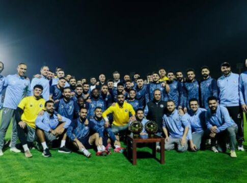 Elenco do Pyramids FC posando com troféu durante treino