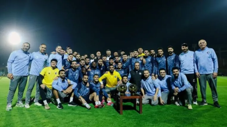 Elenco do Pyramids FC posando com troféu durante treino