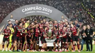 Jogadores do Flamengo levantam o troféu da Libertadores no gramado