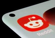 Dedo prestes a pressionar o ícone do aplicativo Reddit