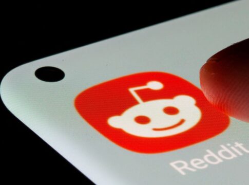Dedo prestes a pressionar o ícone do aplicativo Reddit