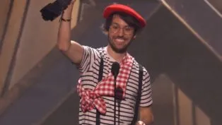 Homem vestido com roupas de mímico levantando troféu