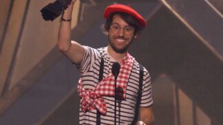 Homem vestido com roupas de mímico levantando troféu