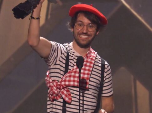 Homem vestido com roupas de mímico levantando troféu