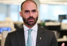 Eduardo Bolsonaro, de terno e gravata, durante entrevista