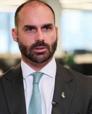 Eduardo Bolsonaro, de terno e gravata, durante entrevista