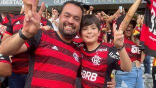 O governador do Rio, Cláudio Castro, gesticula em foto com seu filho na arquibancada; ambos vestem camisa do Flamengo