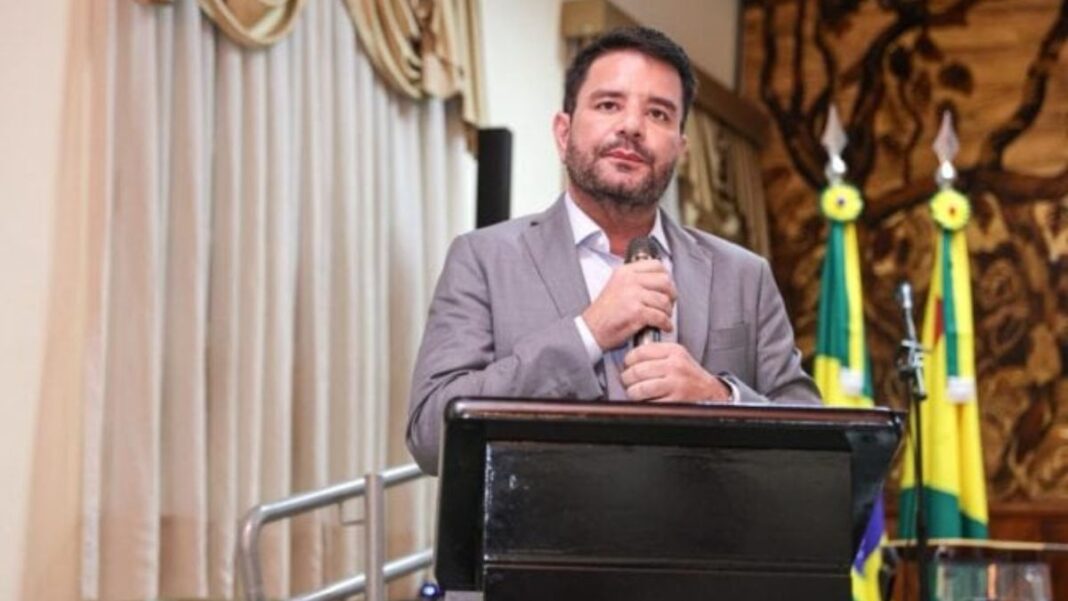 Governador do Acre segura o microfone com as duas mãos durante evento