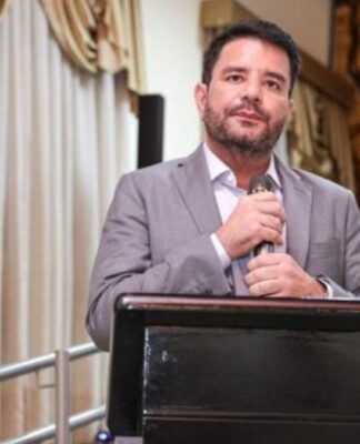 Governador do Acre segura o microfone com as duas mãos durante evento