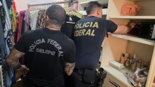 Policiais federais vasculham armário dentro de casa de um dos suspeitos