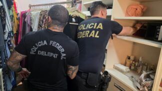 Policiais federais vasculham armário dentro de casa de um dos suspeitos