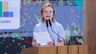 Gleisi Hoffmann fala ao microfone e segura papel durante discurso