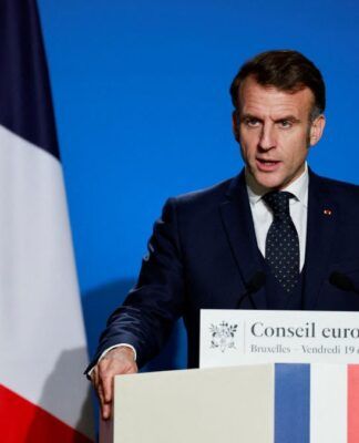 Presidente francês Emmanuel Macron fala no púlpito com bandeiras da França e da União Europeia ao fundo