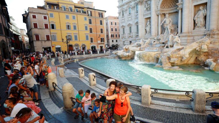 Turistas fazem fotos na beira da Fontana