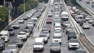 Fileiras de carros engarrafados em rua de São Paulo