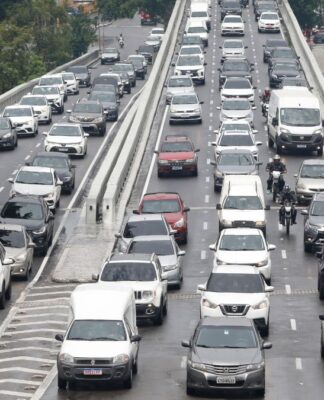 Fileiras de carros engarrafados em rua de São Paulo