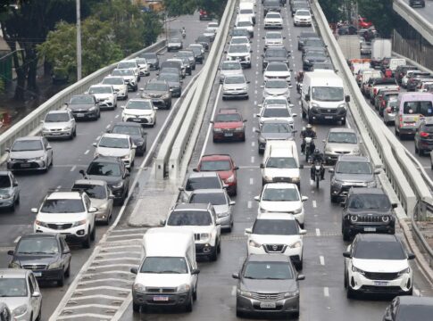 Fileiras de carros engarrafados em rua de São Paulo