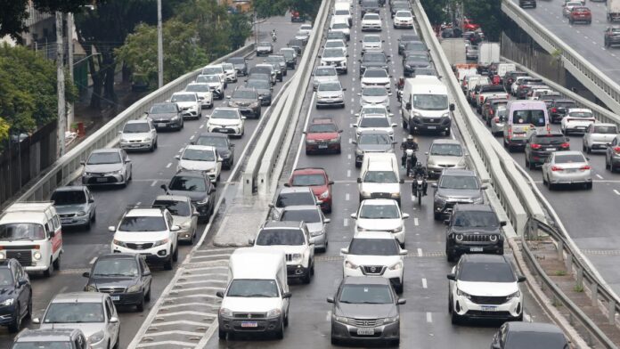 Fileiras de carros engarrafados em rua de São Paulo