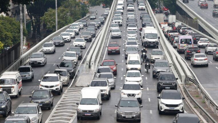 Fileiras de carros engarrafados em rua de São Paulo