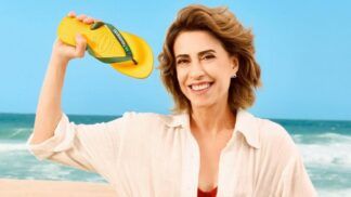 Atriz Fernanda Torres segura com a mão uma Havaianas de cor amarela e verde