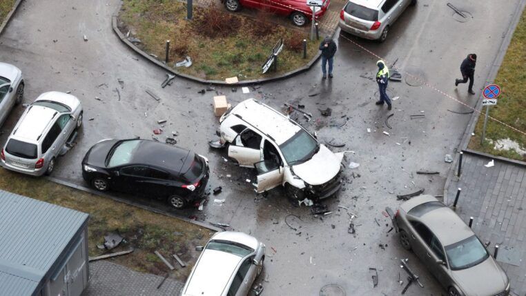 Carro branco danificado após ataque a bomba