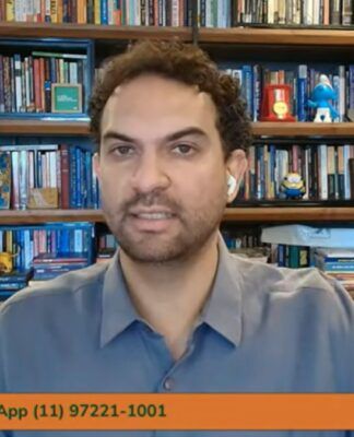 Felipe Nunes aparece na entrevista por video, com prateleiras com livros ao fundo