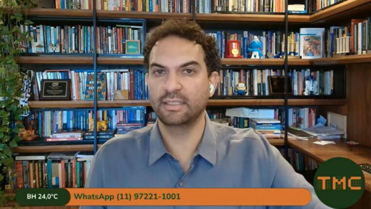 Felipe Nunes aparece na entrevista por video, com prateleiras com livros ao fundo