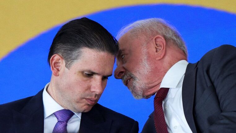 Lula fala ao ouvido de Hugo Motta durante cerimônia no Planalto
