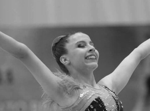 Ginasta finaliza apresentação com as duas mãos para o ar