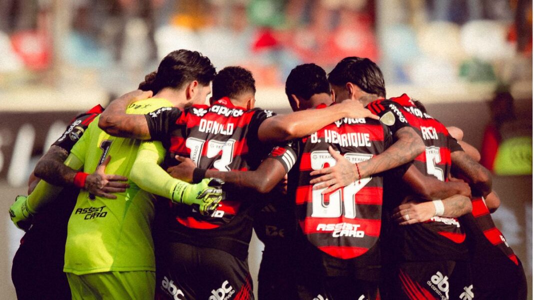 Atletas do Flamengo reunidos em círculo antes da partida contra o Palmeiras