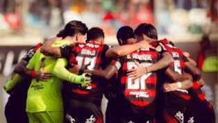 Atletas do Flamengo reunidos em círculo antes da partida contra o Palmeiras
